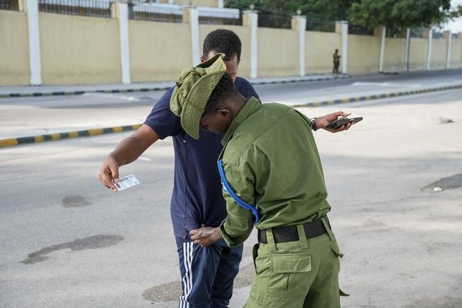 Seorang anggota pasukan keamanan Somalia menggeledah seorang pemilih di jalan selama pemilihan kota di Mogadishu, 25 Desember 2025.