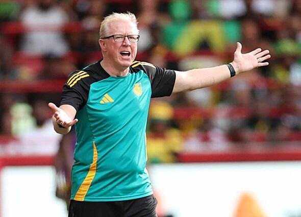 Seseorang yang mengenakan seragam olahraga berwarna hijau dan hitam dengan aksen kuning aktif menggerakkan tangan dengan tangan terentang Seseorang yang mengenakan seragam olahraga berwarna hijau dan hitam dengan aksen kuning aktif menggerakkan tangan dengan tangan terentang