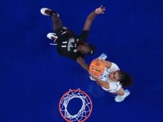 Staley menyambut wisuda UCLA sebelum pertandingan perebutan gelar, lalu menyeringai ke arah penonton setelah drama jabat tangan