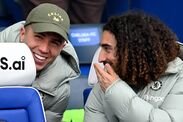 LONDON, INGGRIS – 4 APRIL: Pemain Chelsea Enzo Fernandez dan Marc Cucurella berinteraksi di bangku cadangan sebelum Emirates FA Cup Quar