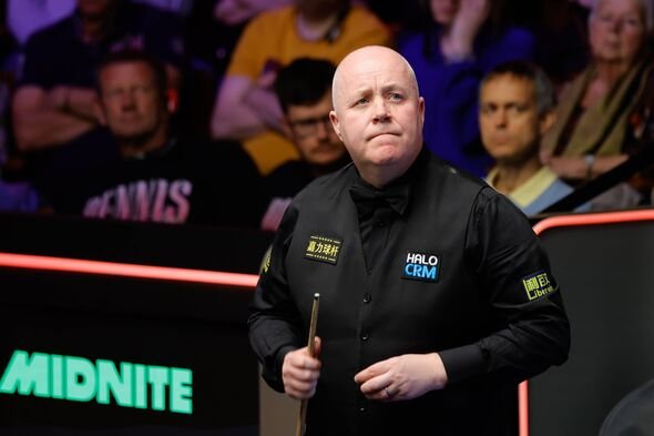 John Higgins melihat ke papan skor.