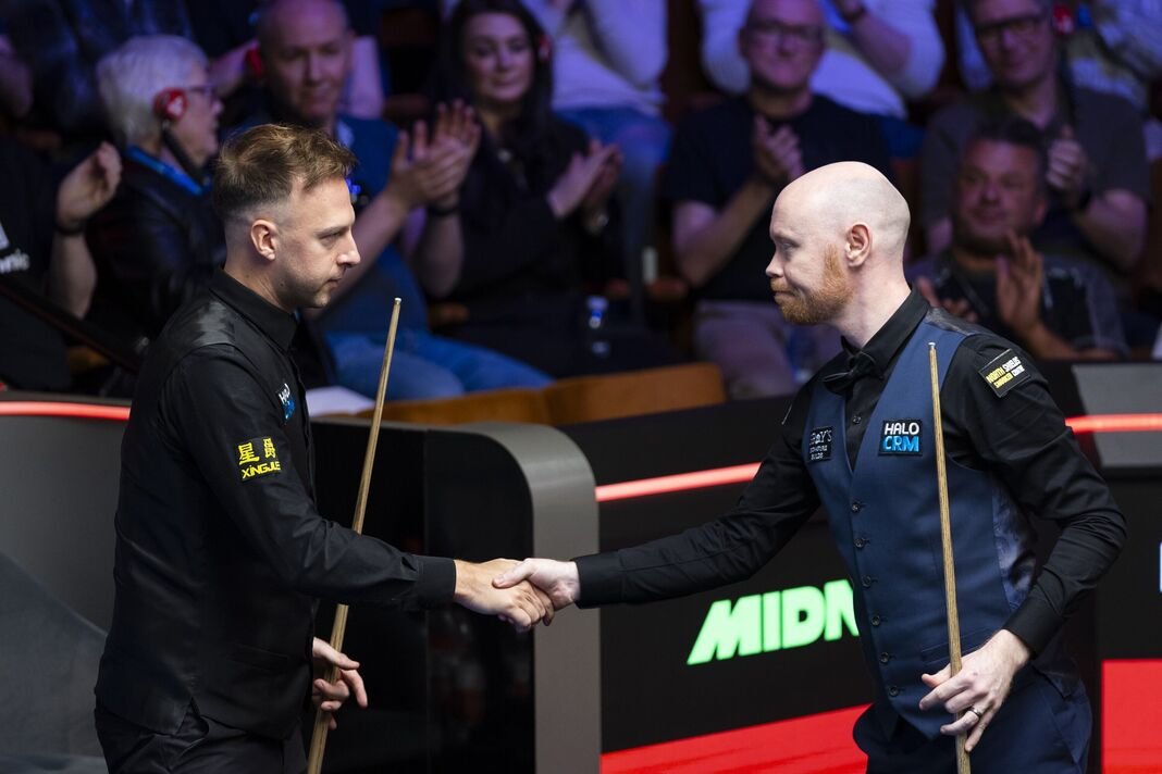 Judd Trump dan Gary Wilson berjabat tangan